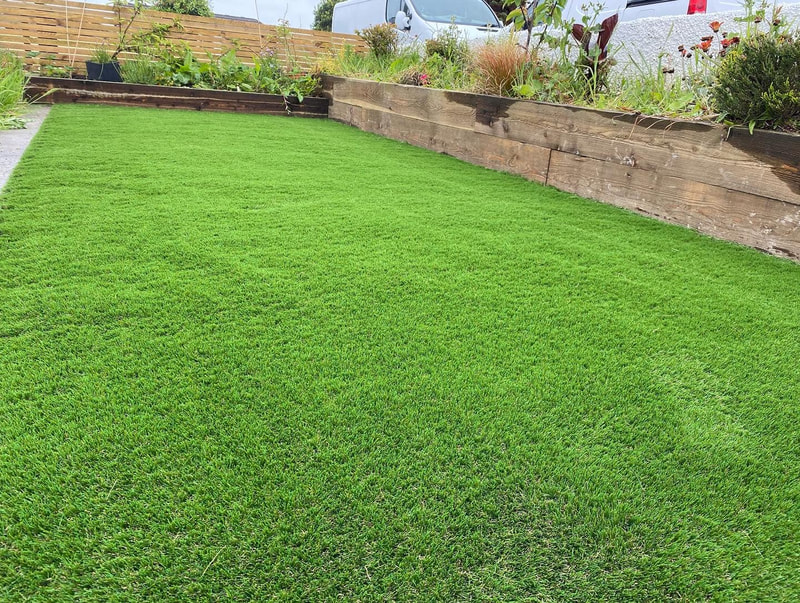 Garden with timber sleeper borders, ideal composite decking backdrop