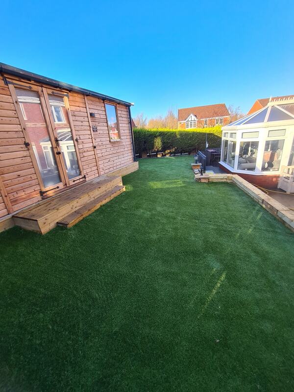 Timber building installation alongside artificial grass